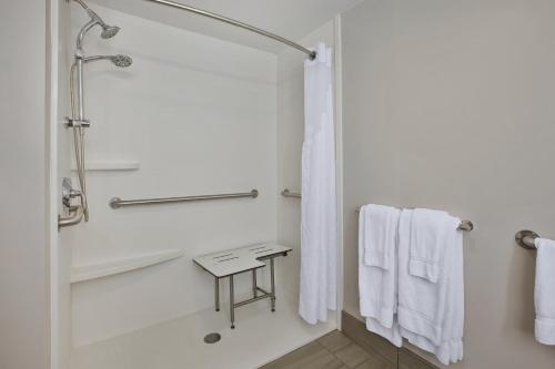 a bathroom with a shower and white towels at Holiday Inn Express Tiffin, an IHG Hotel in Tiffin