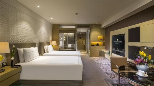 a hotel room with two beds and a television at InterContinental Shanghai Jing' An by IHG in Shanghai