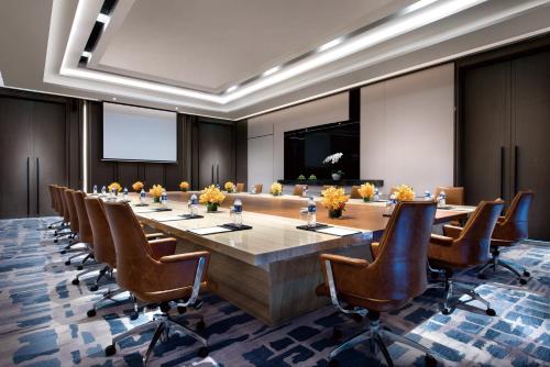 una gran sala de conferencias con una mesa larga y sillas en Crowne Plaza Shanghai Pujiang, an IHG Hotel en Shanghái