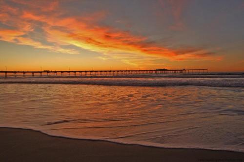 a beach with a pier in the ocean at sunset at GreenTree Inn San Diego Mission Bay in San Diego