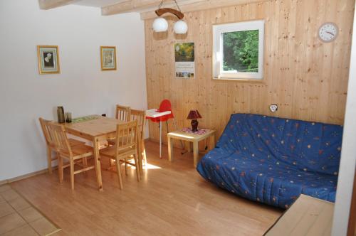 a living room with a blue couch and a table at Słowińska Natura in Smołdziński Las