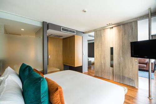 a bedroom with a bed and a flat screen tv at Hotel Vista in Pattaya Central