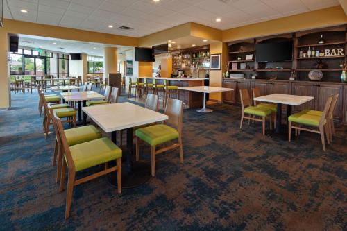a restaurant with tables and chairs and a bar at Holiday Inn Palmdale-Lancaster by IHG in Palmdale