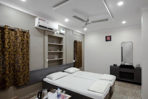 a bedroom with a bed and a tv in it at Hotel AKMG in Dindigul