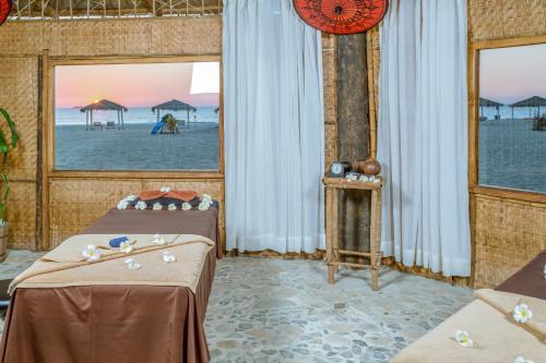 a room with two beds and a view of the beach at Eskala Hotels and Resorts in Ngwesaung
