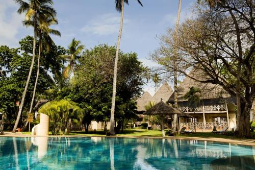 uma piscina em frente a um resort com palmeiras em Neptune Palm Beach Boutique Resort & Spa - All Inclusive em Galu