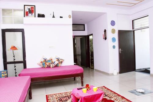 a living room with two beds and a table at Maison Jaipur in Jaipur