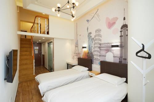 2 camas en una habitación con un mural en la pared en Shanghai Meego Qingwen Hotel en Shanghái