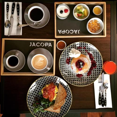 ein Tisch mit Tellern mit Essen und Tassen Kaffee in der Unterkunft Hotel San Francesco in Rom