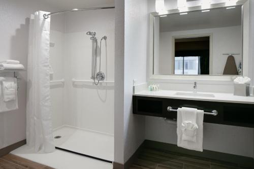 biała łazienka z prysznicem i umywalką w obiekcie Holiday Inn Hotel & Suites Overland Park-West, an IHG Hotel w mieście Overland Park