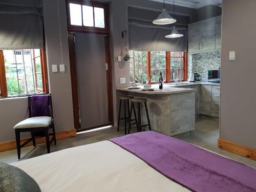 a bedroom with a large kitchen with a purple rug at Rozenhof Guest Cottages in George