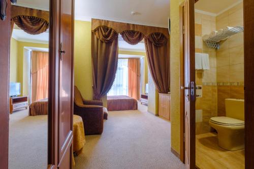 a bathroom with a toilet and a sink in a room at Hotel Feodosiya in Feodosia