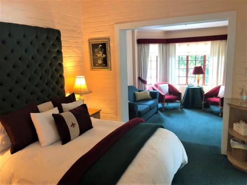 a bedroom with a large bed and a living room at Edenwood House in George
