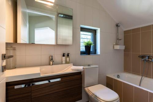 a bathroom with a sink and a tub and a toilet at Villa Idyle - Luxury Beachfront Residence in Tragána