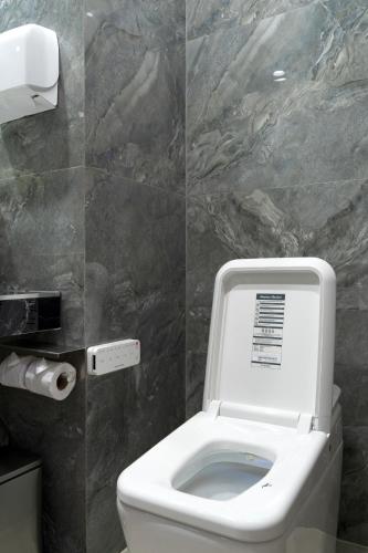 a bathroom with a toilet with the lid up at Salee Boutique Hotel in Chiang Mai