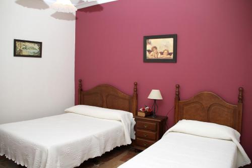 duas camas num quarto com paredes roxas em Chacón em Prado del Rey