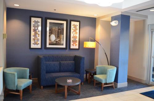 a waiting room with a blue couch and chairs at Holiday Inn Express Hotel & Suites Anniston/Oxford by IHG in Oxford
