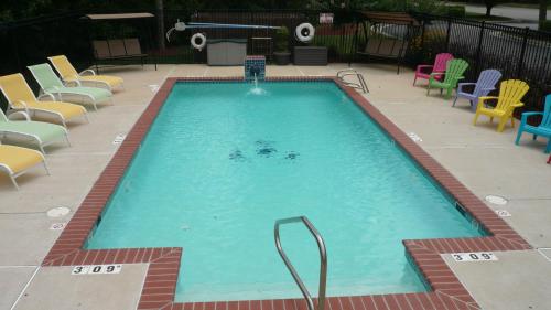 una gran piscina con sillas y sillas. en Candlewood Suites Newport News-Yorktown, an IHG Hotel, en Newport News
