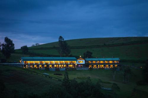a large building in a field at night at Destiny - The Farm Resort in Ooty
