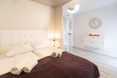 a bedroom with a large bed with a clock on the wall at Apartament Pod Czantorią z tarasem - Dream Apart in Ustroń