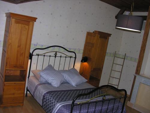 a bedroom with a bed and two wooden cabinets at Hortensia du Der Familial in Montier-en-Der