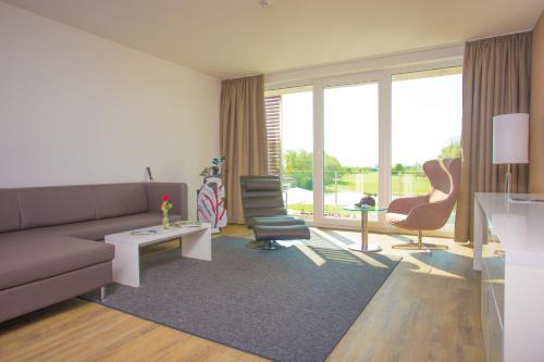 een woonkamer met een bank en 2 stoelen bij Hotel absolute in Gernsheim
