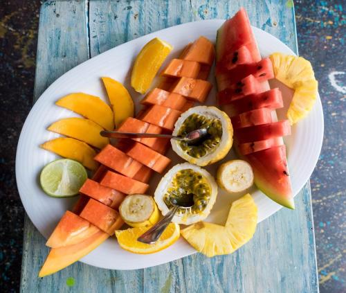 a plate of fruit on a wooden table at Karmel Villa Thalduwa Island - Five Bedroom Luxury Villa with Private Pool in Ahangama