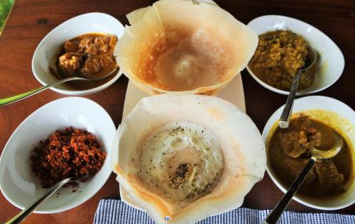 a table topped with bowls of different types of food at Karmel Villa Thalduwa Island - Five Bedroom Luxury Villa with Private Pool in Ahangama