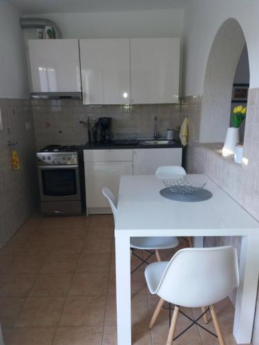 una cucina con tavolo bianco e sedie bianche di Apt Ingrid a Pola (Pula)