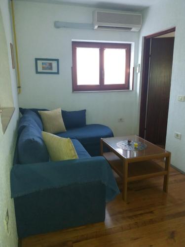 a living room with a blue couch and a table at Apt Ingrid in Pula