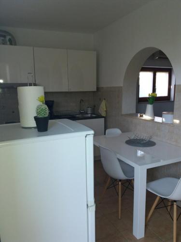 a kitchen with a white table and chairs and a table and a counter at Apt Ingrid in Pula
