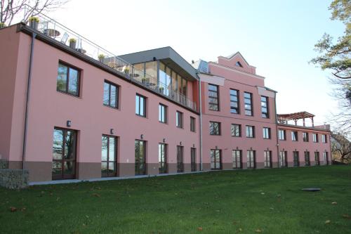 a large pink building with a green lawn at Hotel Cvilín in Krnov