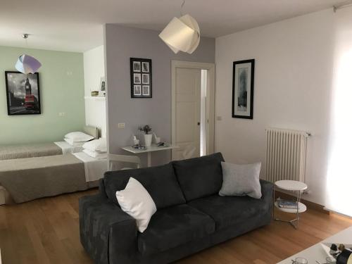 een woonkamer met een bank en een bed bij Le Residenze di Via Lo Re in Foggia