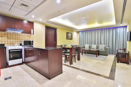 a kitchen and dining room with a table and chairs at Telal Hotel Apartments in Dubai