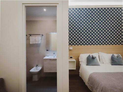 a bedroom with a bed and a bathroom with a sink at My Maison 109 Guest House in Rome