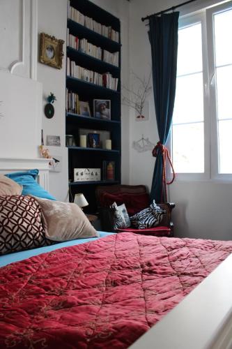 - une chambre avec un grand lit rouge et une fenêtre dans l'établissement Le Boudoir d'artiste, à Semur-en-Auxois