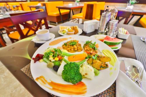 a plate of food with vegetables on a table at Telal Hotel Apartments in Dubai
