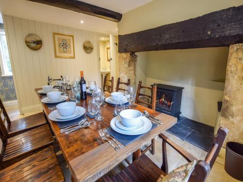 a dining room with a table and a fireplace at Archers in Winchcombe