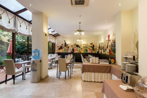 a dining room with tables and chairs and paintings on the wall at Coroana Brasovului in Braşov