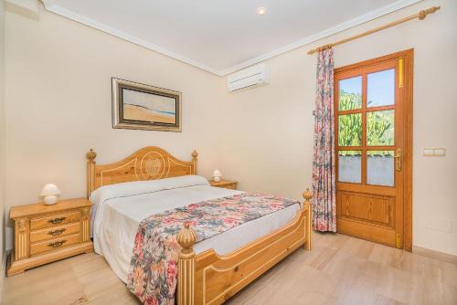 Schlafzimmer mit einem Bett, einem Fenster und einer Tür in der Unterkunft Vistamar 5A - Puerto de Alcudia in Alcúdia