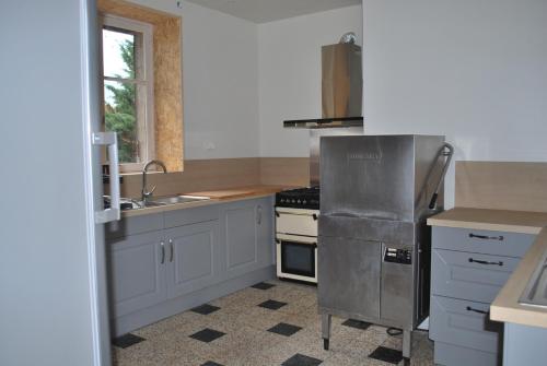 a kitchen with a sink and a stove top oven at Gite de la Gare in Varzy