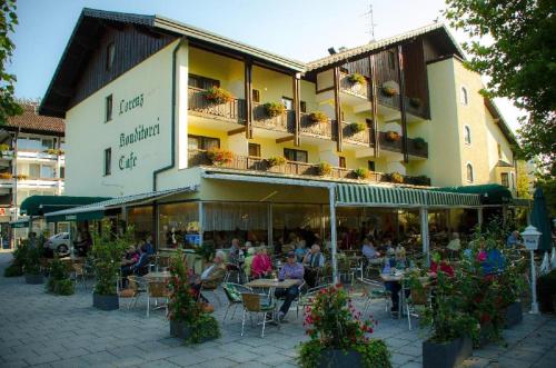 a group of people sitting at tables outside of a building at Hotel Lorenz in Bad Füssing
