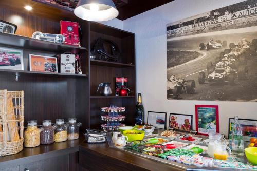 a restaurant with a counter with food on it at Enzo Hotels Reims Tinqueux by Kyriad Direct in Reims