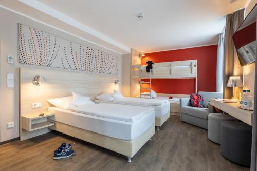a hotel room with two beds and a couch at Serways Hotel Reinhardshain Nord in Grünberg