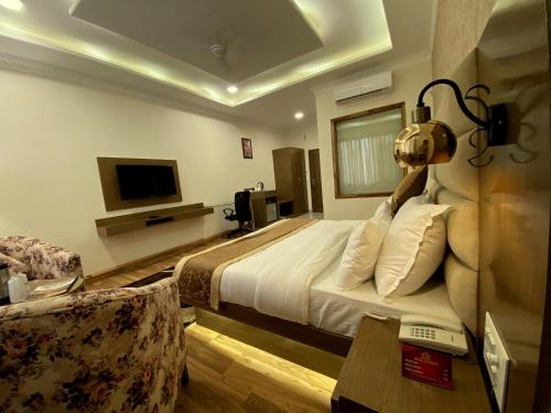 a hotel room with a bed and a tv at Royal Mansion in Kulu