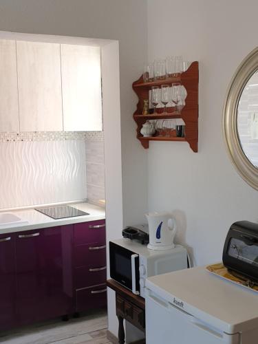 a kitchen with purple cabinets and a microwave at Lovely studia in Las Galletas con nice sea view in Las Galletas