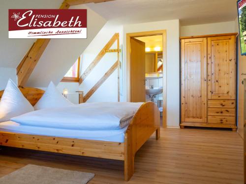 ein Schlafzimmer mit einem Bett in einem Zimmer mit einer Treppe in der Unterkunft Pension Elisabeth in Todtnauberg