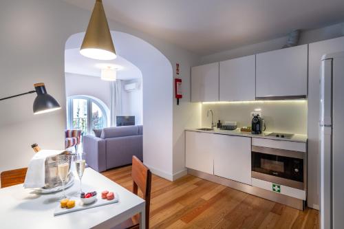 a kitchen with a stove, refrigerator, sink, and dishwasher at My Suite Lisbon Guest House – Principe Real in Lisbon