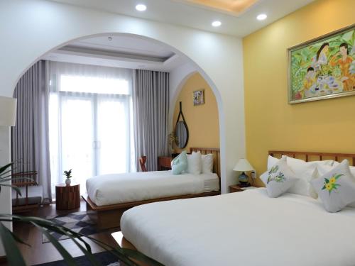 a hotel room with two beds and a window at Chez Mimosa Local in Ho Chi Minh City