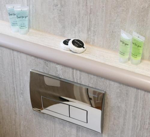 a shelf with two bottles of soap and a mirror at The Queen's Head Hotel in Buxton